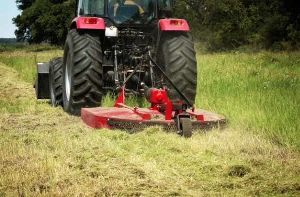 Tractor with rotary cutter mowing a rural pasture — Texas Land Creations