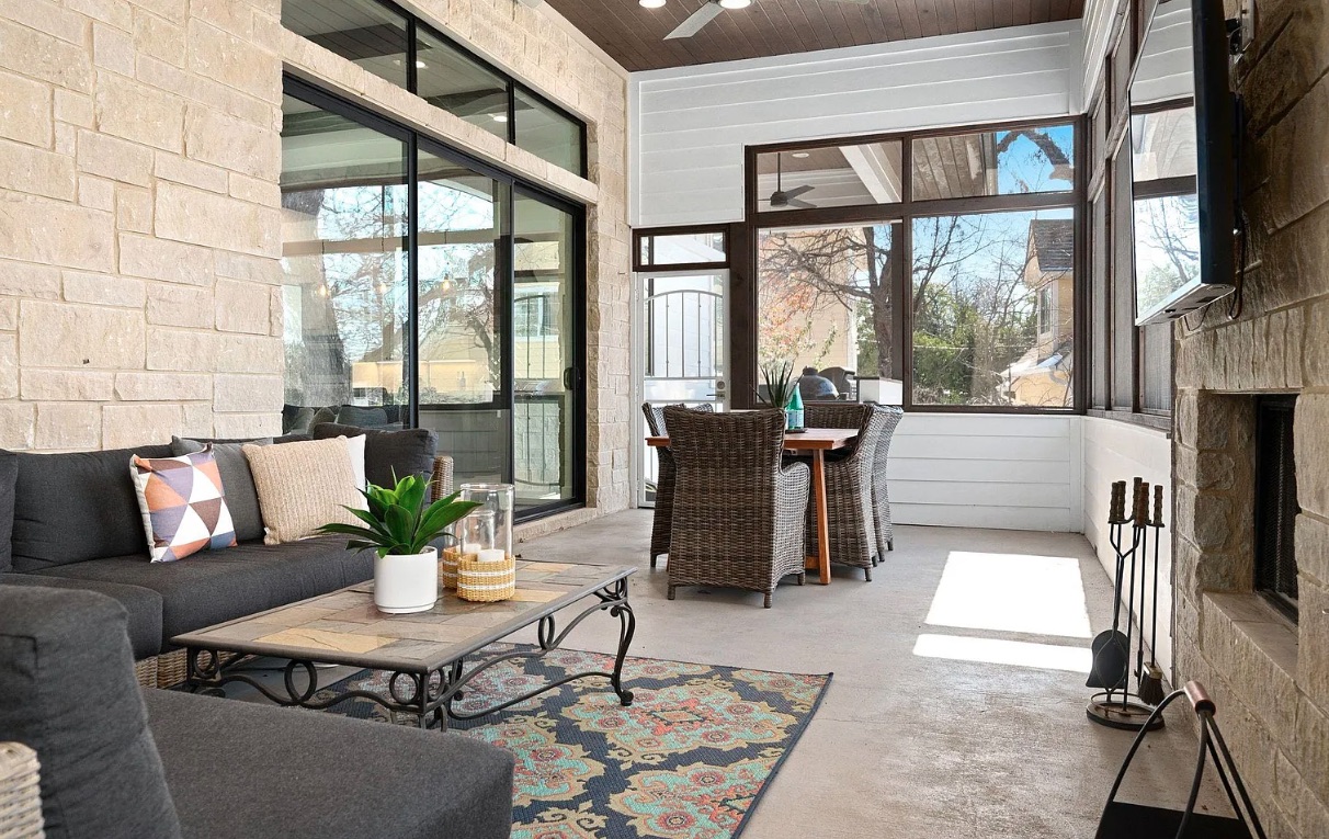Enclosed patio with stone accents, lounge seating, and fireplace — Texas Land Creations